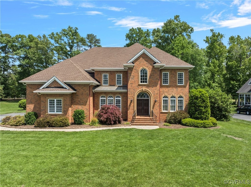 Colonial inspired home featuring a front yard, bri