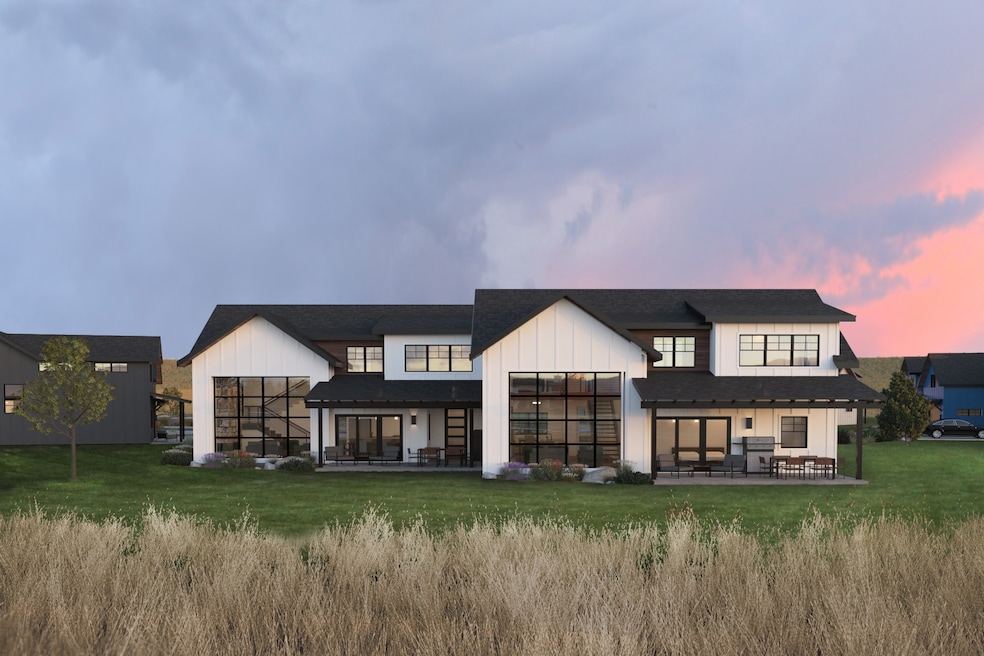 Back house at dusk with a yard and a patio
