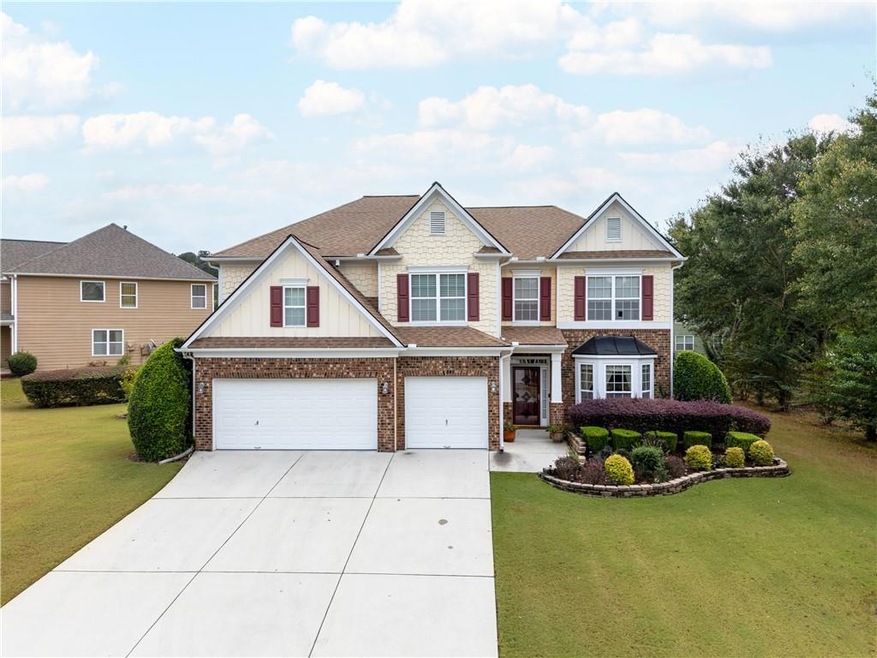 Craftsman-style house featuring concrete driveway, a front yard, board and batten siding, and roof with shingles