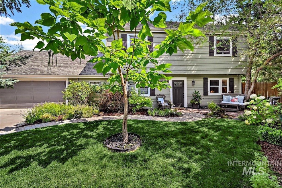 View of front of home with an attached garage, driveway, and an outdoor living space