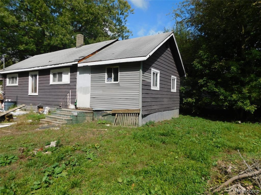 Rear view of house featuring a chimney