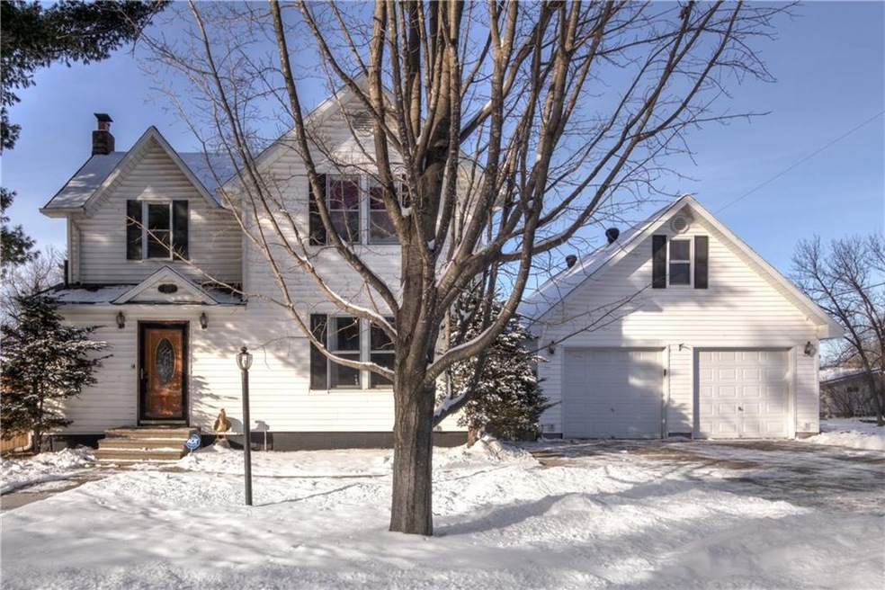 Front view with mature trees and concrete drive to