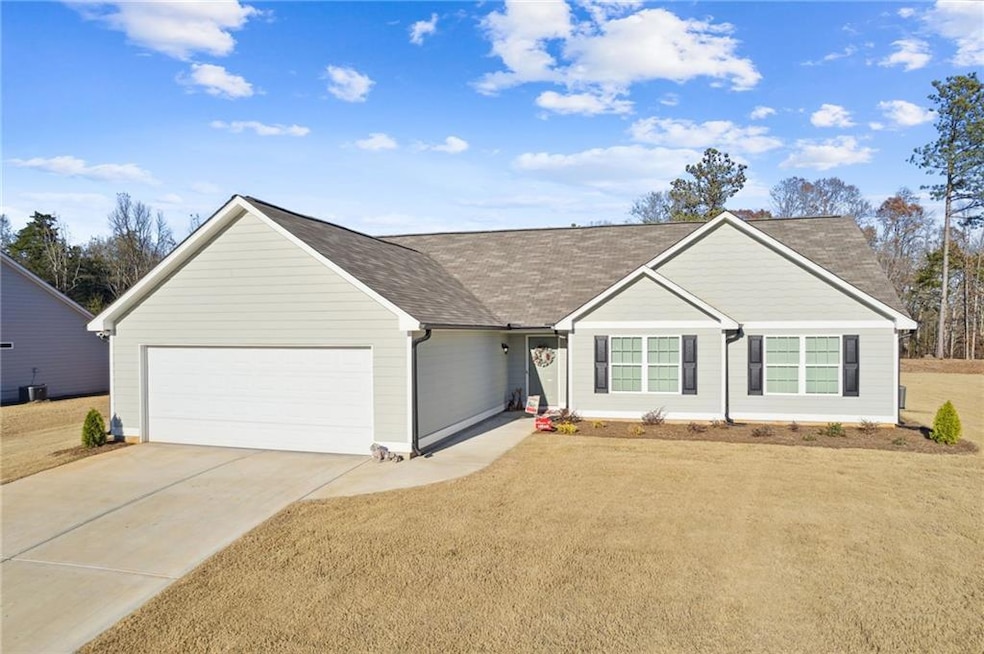 Single story home featuring a front yard, a garage