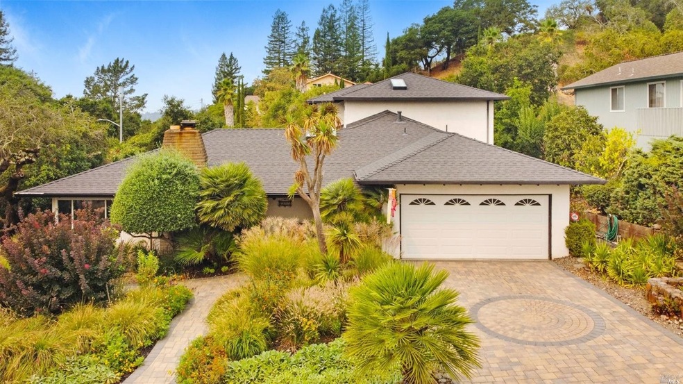 Aerial view capturing the exterior beauty of home, landscaping and custom paver driveway & walkways