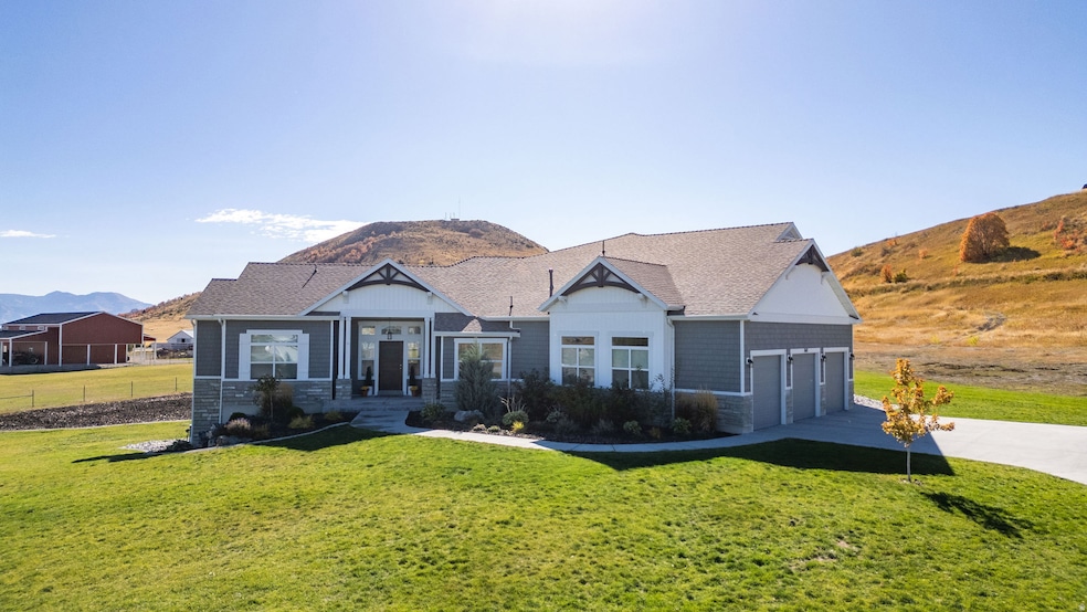 View of front of house featuring a mountain view, a front yard, a garage, and concrete driveway