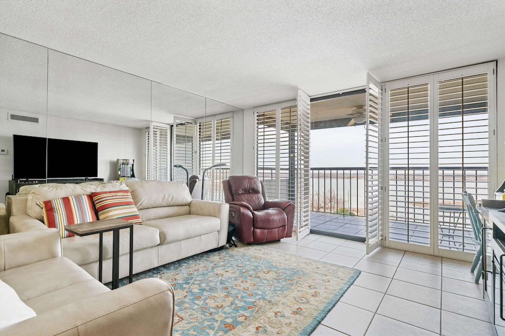 Tiled living room with floor to ceiling windows, a