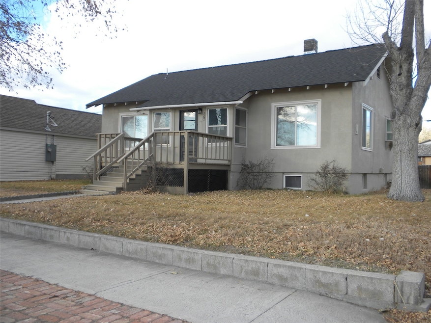 View of front of home with roof with shingles, stucco siding, a chimney, and a deck