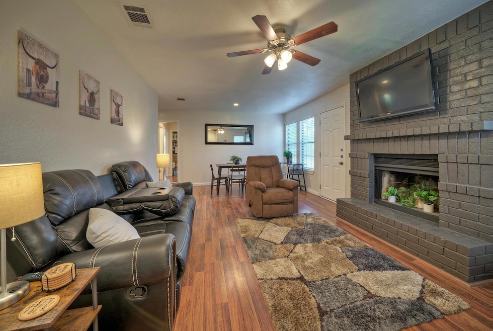 Living room with ceiling fan, wood finished floor
