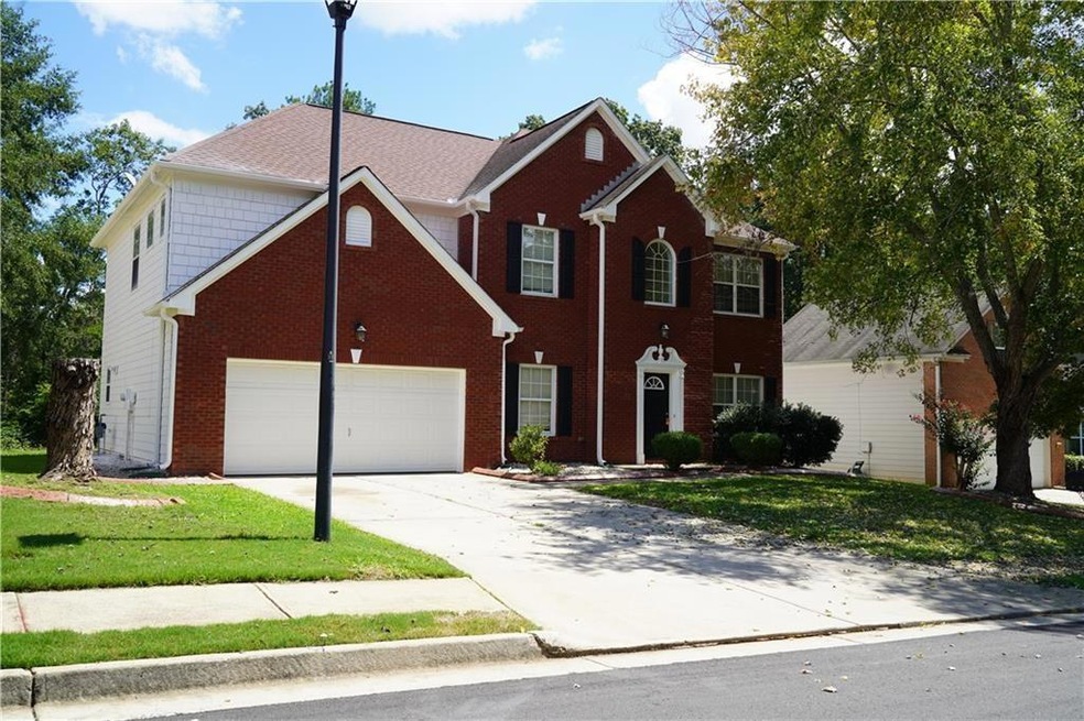 View of front of house with a garage and a front y