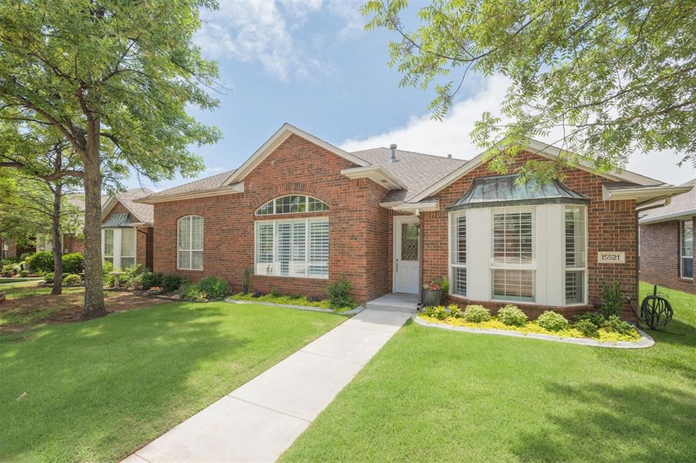 View of front of home featuring brick siding, a front lawn, and roof with shingles