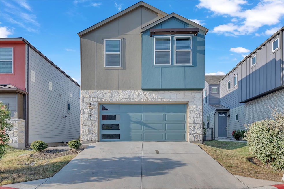 Contemporary home featuring stone siding, an atta