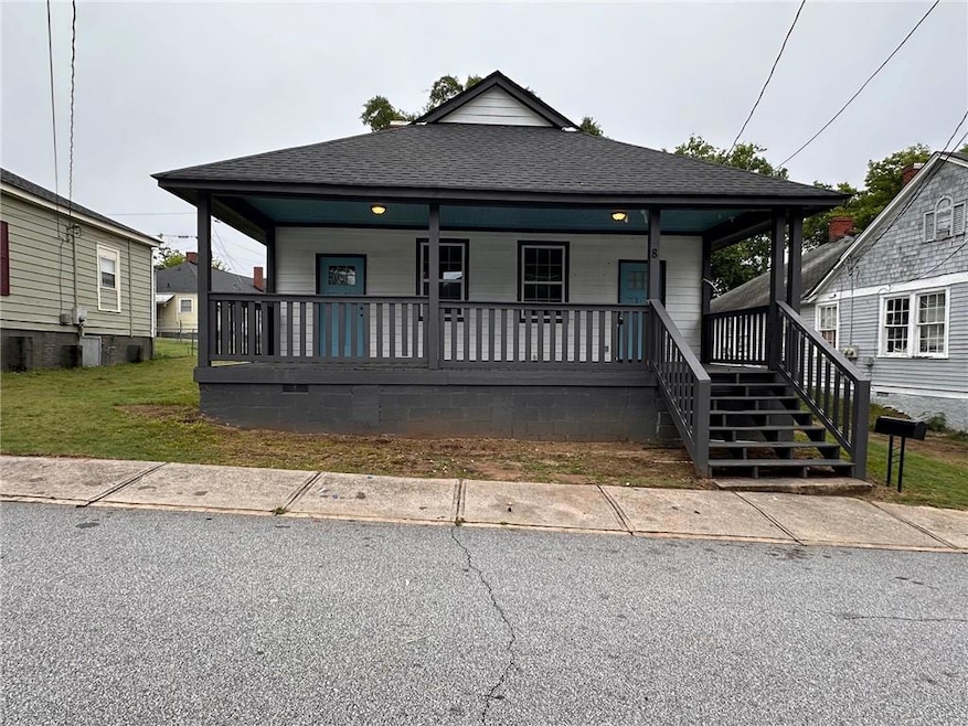 Shotgun-style home featuring covered porch and a shingled roof