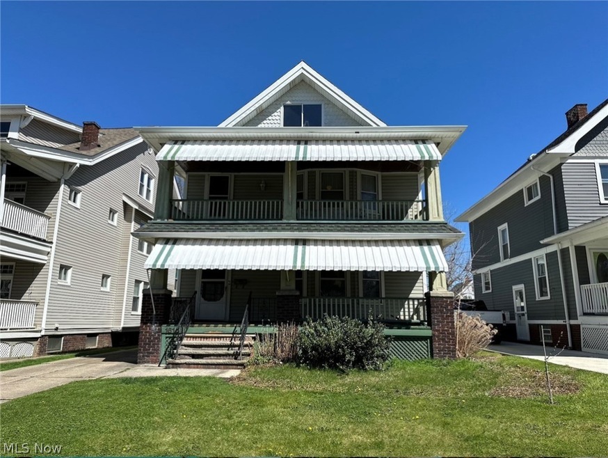 View of front of home with a front lawn and a balcony