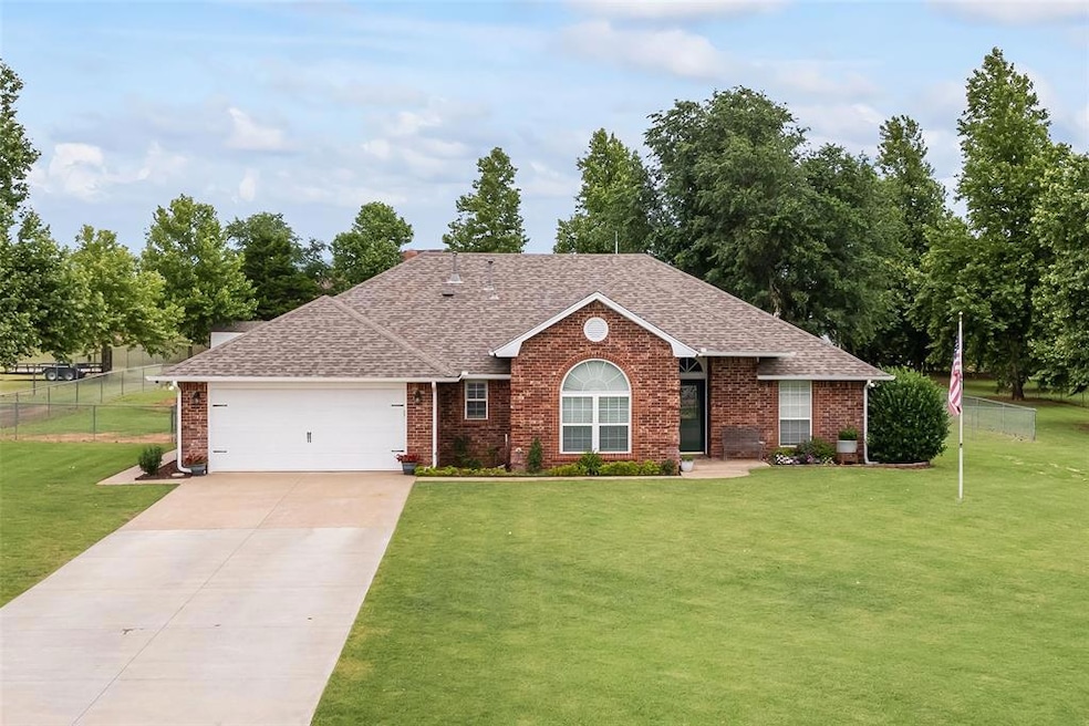 Single story home with a garage and a front lawn