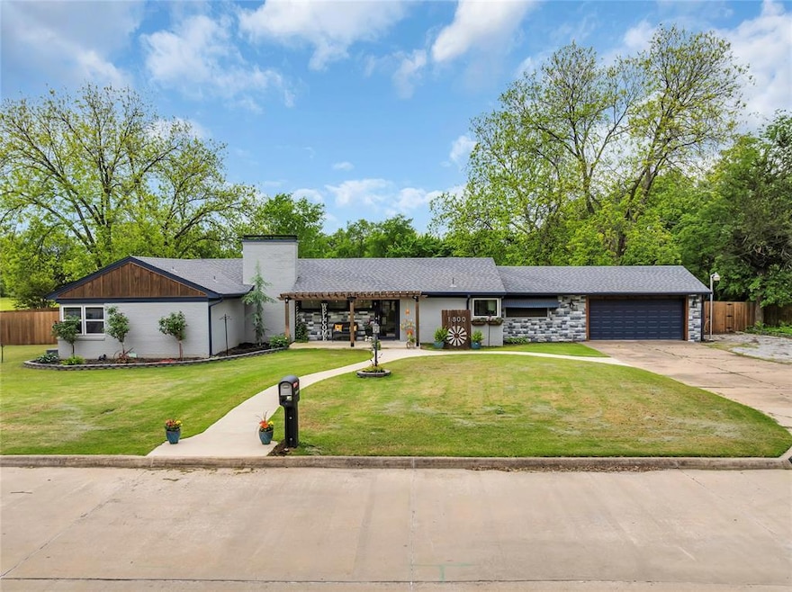 Mid-century modern home featuring driveway, an attached garage, and a chimney
