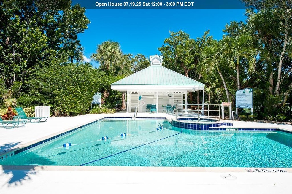 View of pool featuring a patio, a gazebo, a pool with connected hot tub, and view of wooded area