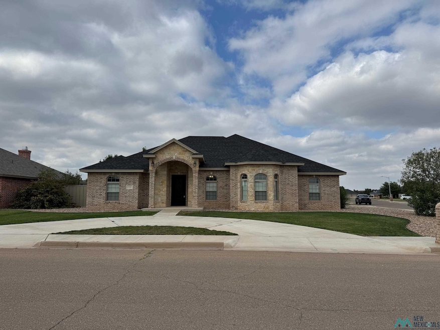 French provincial home featuring brick siding, a shingled roof, a front lawn, and curved driveway