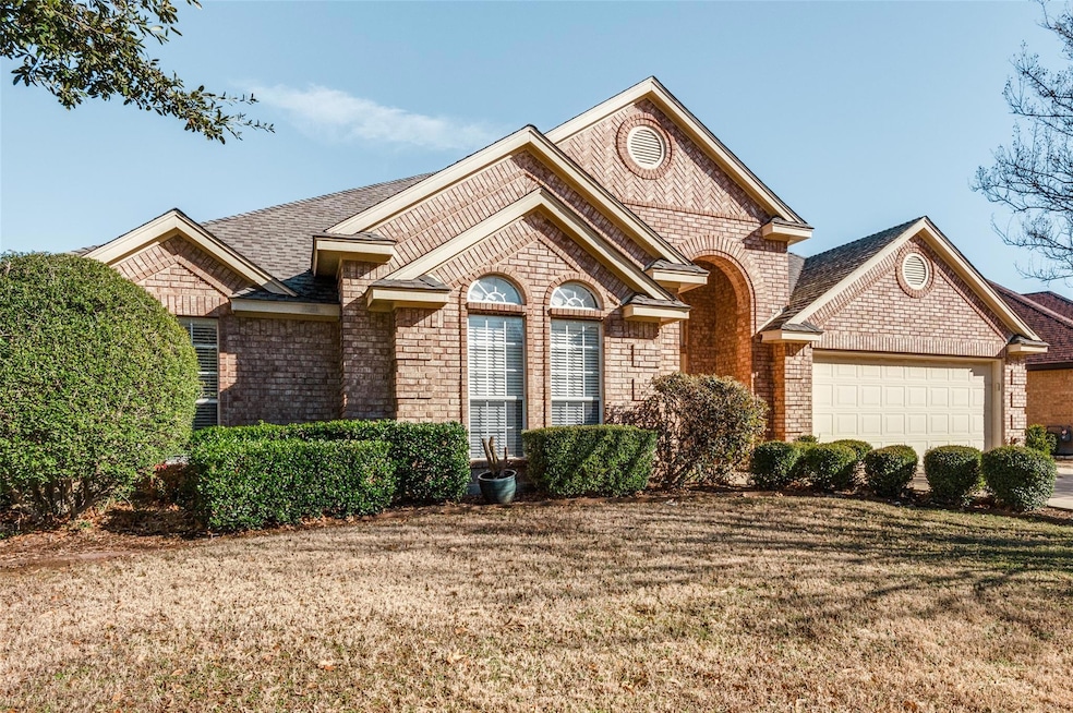 View of front of house featuring a garage, brick s