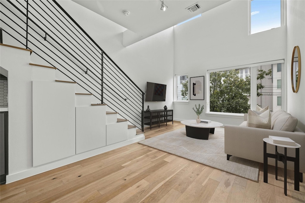 Living room with stairs, baseboards, a towering c