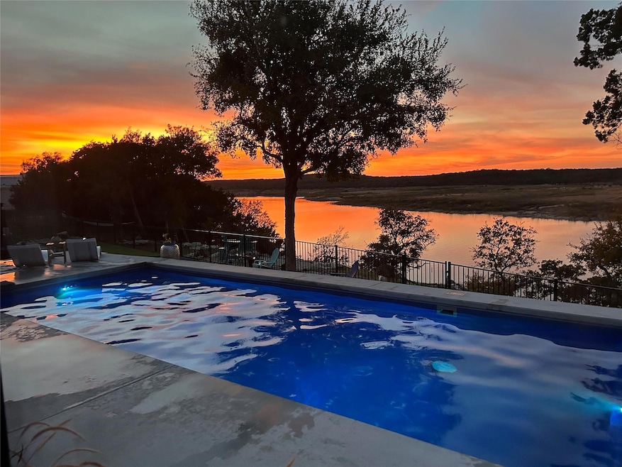 View of pool with a fenced in pool, a water view,