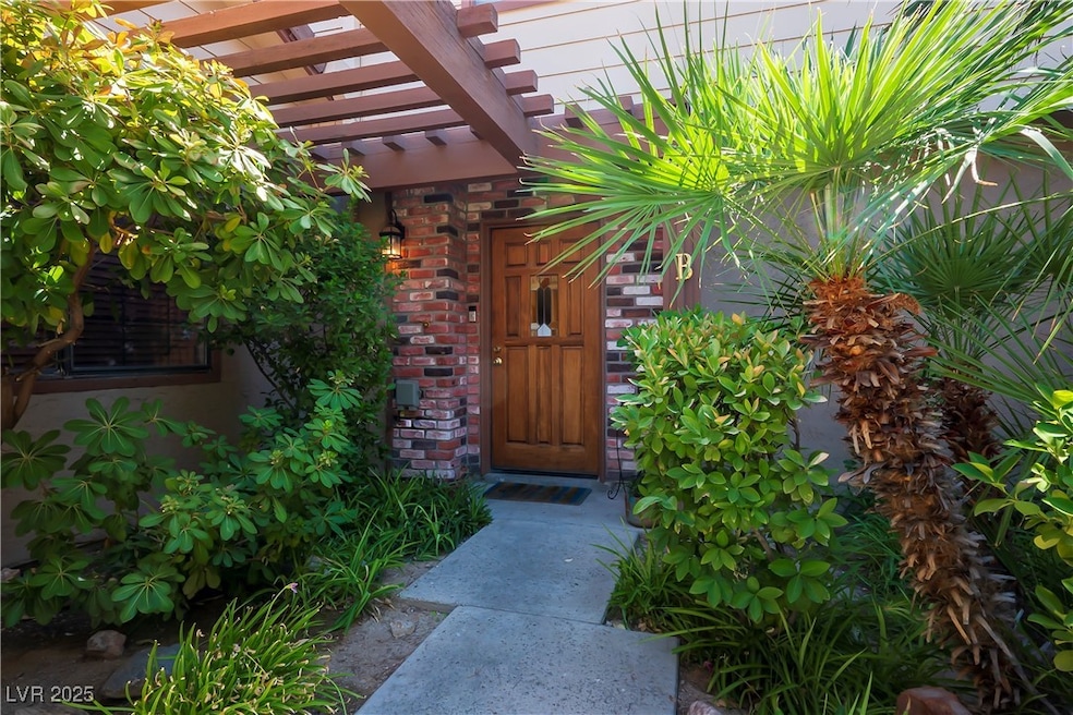View of exterior entry featuring a pergola and bri