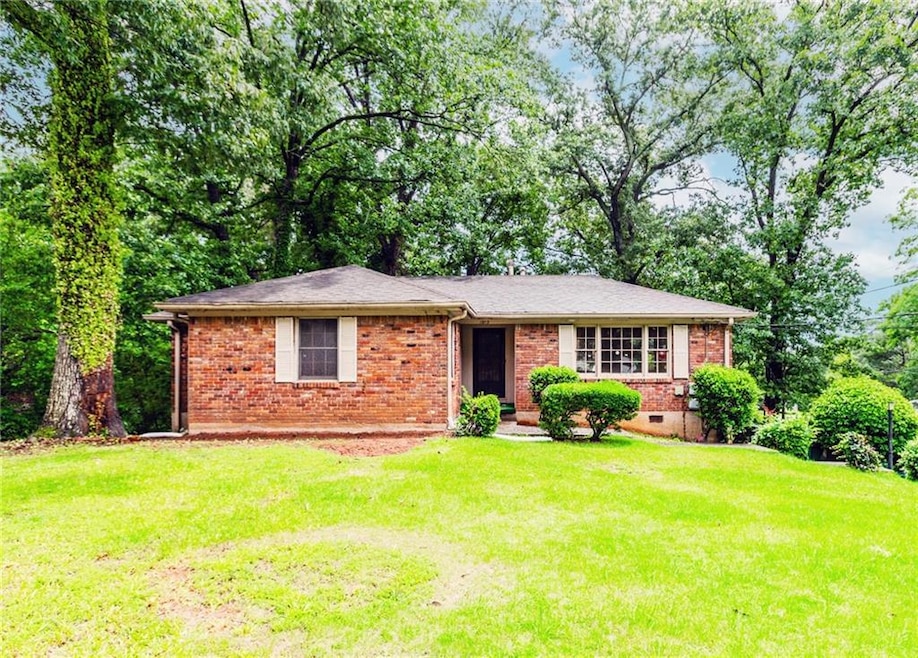 View of front of property featuring brick siding, a front lawn, and crawl space