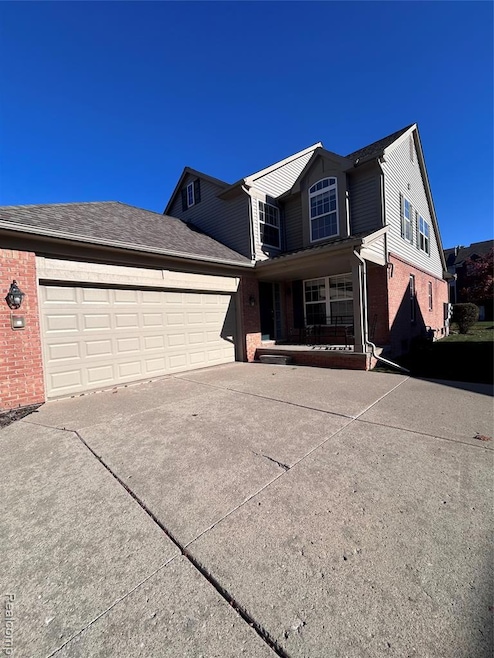 Welcome home featuring covered porch, brick siding, concrete driveway, an attached garage, and roof with shingles