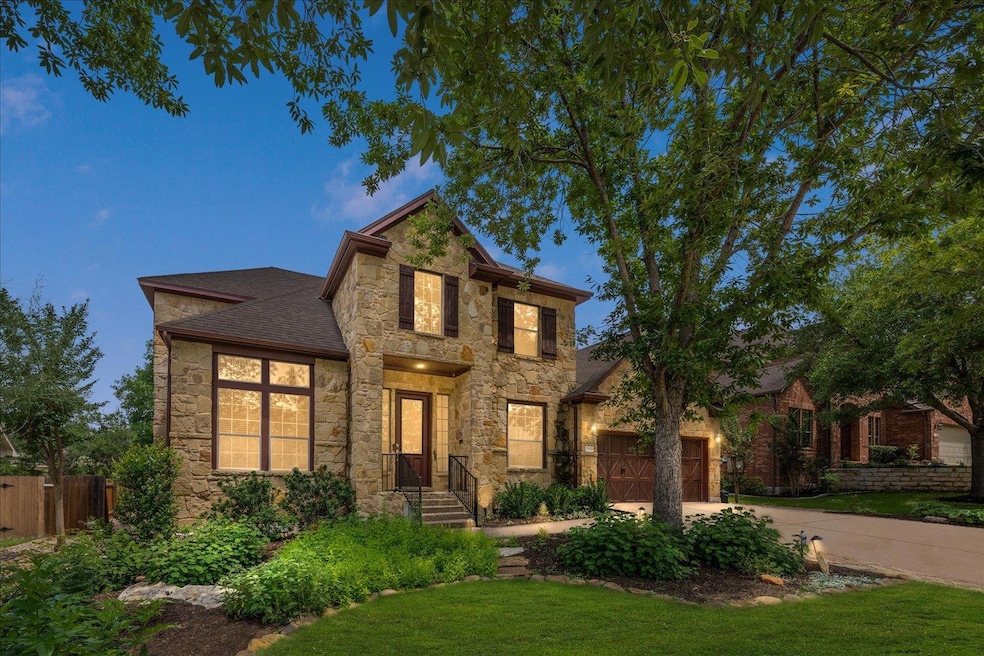 Traditional home featuring stone siding, driveway