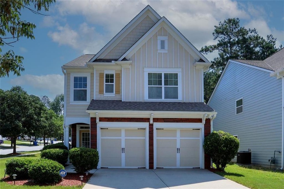Craftsman-style home with board and batten siding, concrete driveway, an attached garage, and brick siding