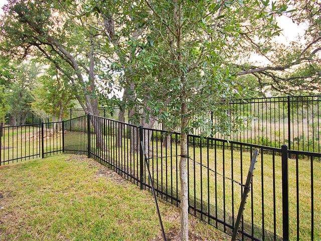 Fenced back yard looking into bird habitat.