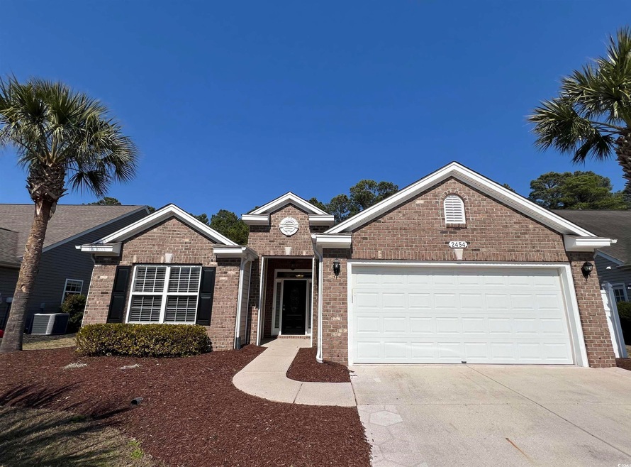 Single story home featuring brick siding, concrete