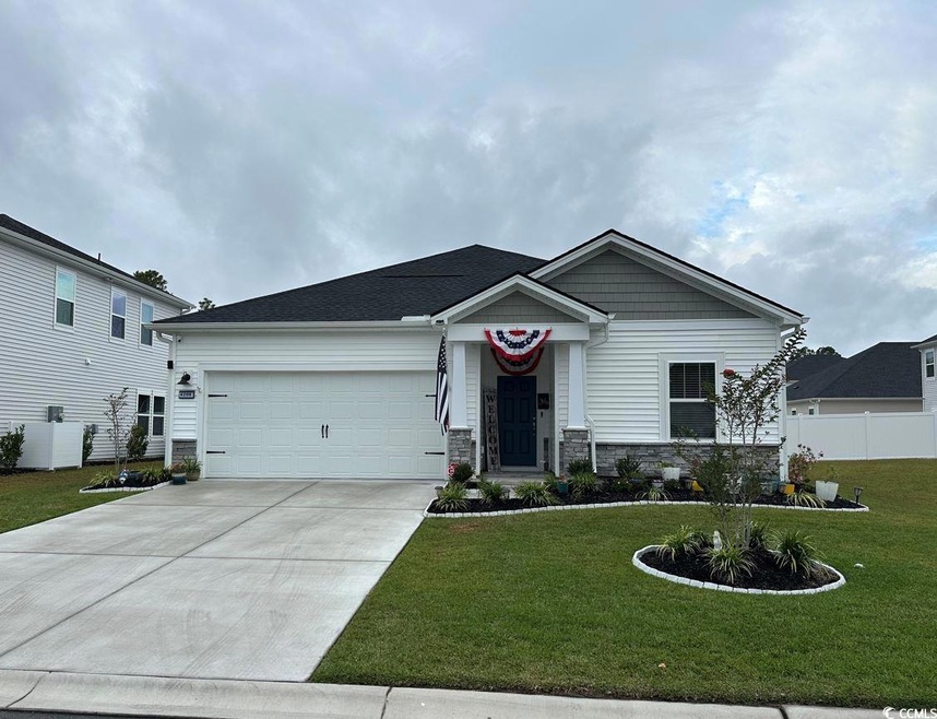 View of front of home with a garage and a front ya