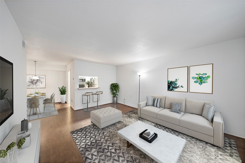 Spacious living area with wood flooring. Virtually staged.