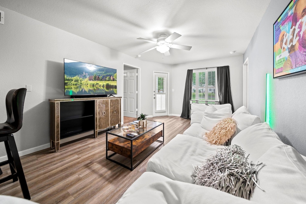 Living room featuring ceiling fan, baseboards, an
