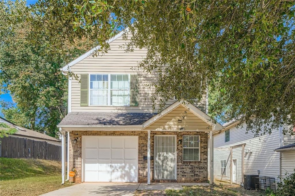 Traditional home with a garage, brick siding, and concrete driveway