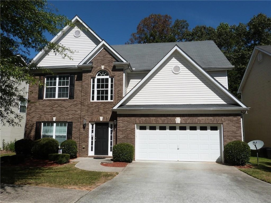Traditional-style house featuring driveway and brick siding