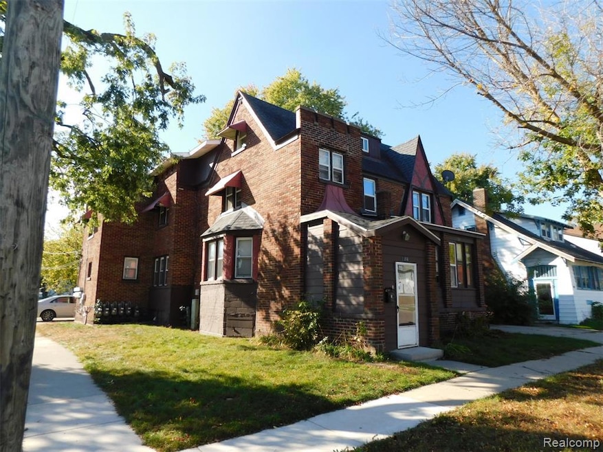 View of front of property with brick siding and a front lawn