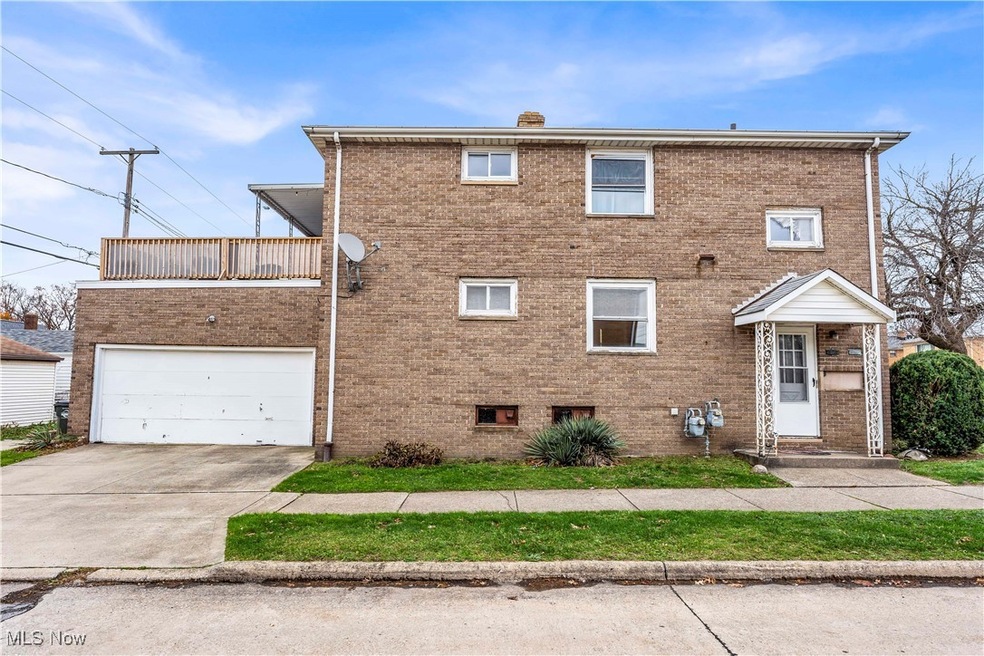 View of front of home with a garage and a balcony