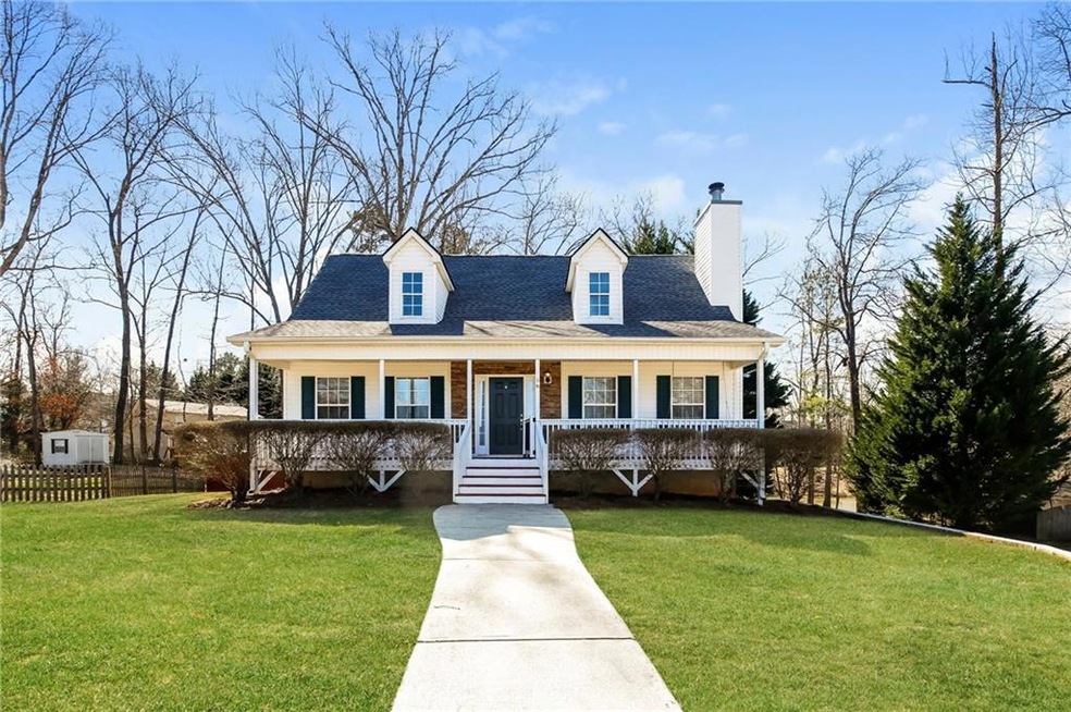 New england style home featuring a porch, a chimney, and a shingled roof