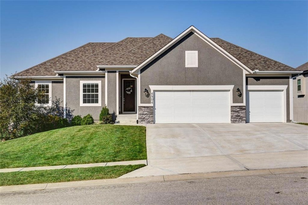 View of front of property with a front yard and a garage