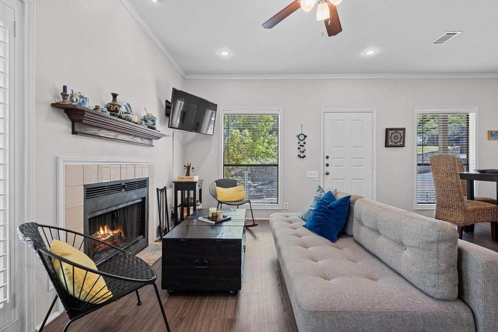 Living room featuring visible vents, a tiled fire