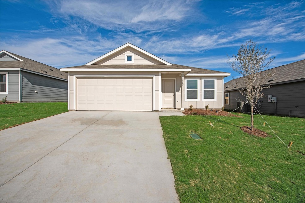 Ranch-style house with a garage and a front lawn
