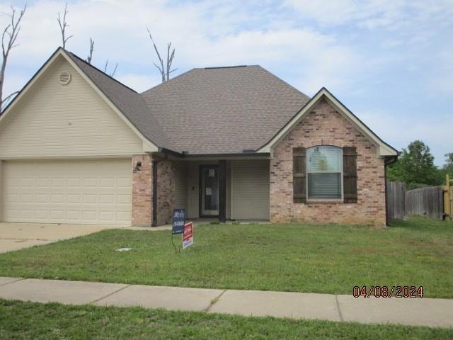 View of front of home with a garage and a front la