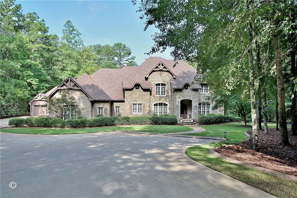 French country style house featuring stone siding, a front yard, and driveway