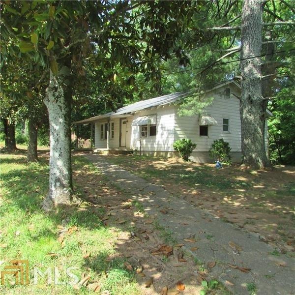 Large mature trees shade the front and back of hom