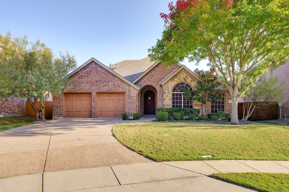View of front of house with brick siding, driveway, a garage, and a shingled roof