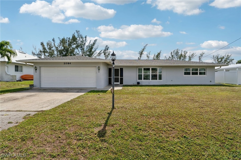 Single story home with a garage and a front lawn
