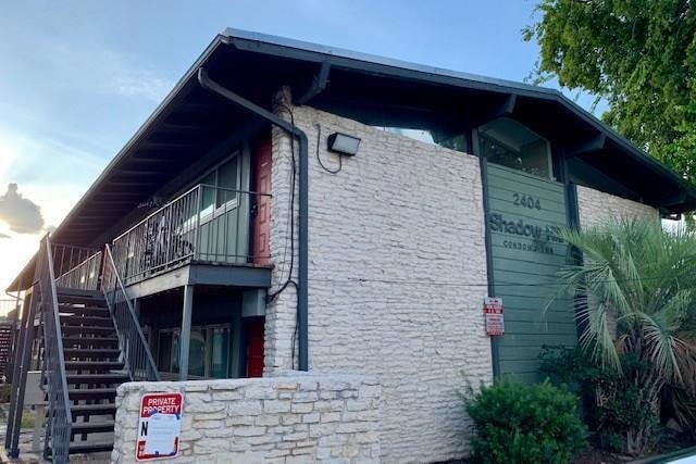 View of side of home with stone siding and stairw