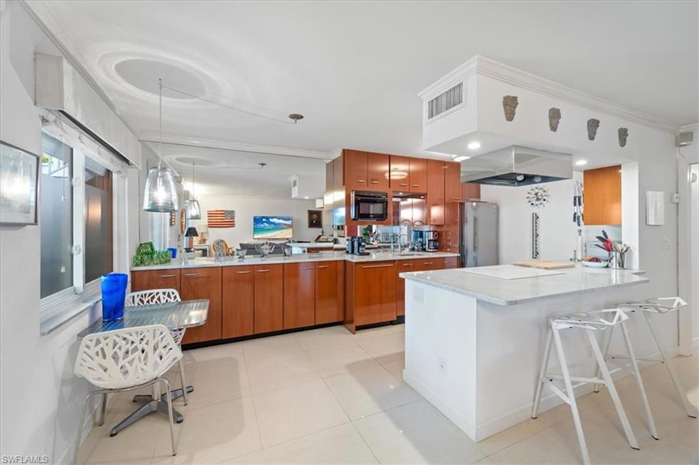 Kitchen with black microwave, a peninsula, brown c