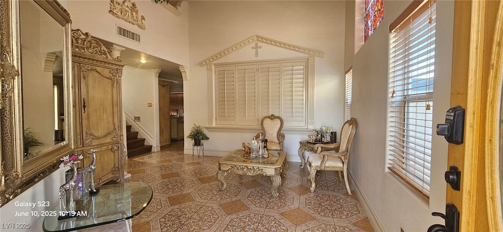 Sitting room with a high ceiling, stairway, and ti